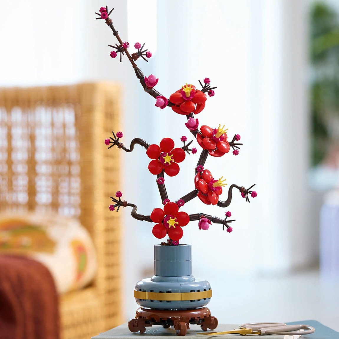 Red-and-magenta LEGO plum blossom flowers in pastel-blue pot