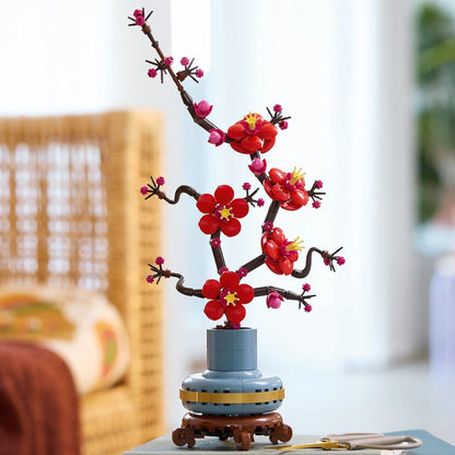 Red-and-magenta LEGO plum blossom flowers in pastel-blue pot